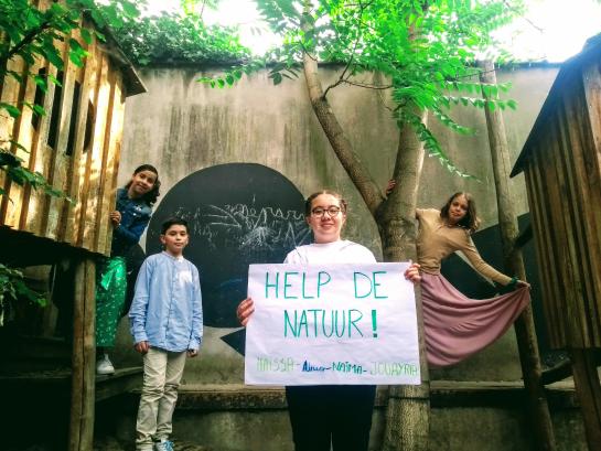 4 kinderen tonen pancarte met slogan 'Help de natuur'